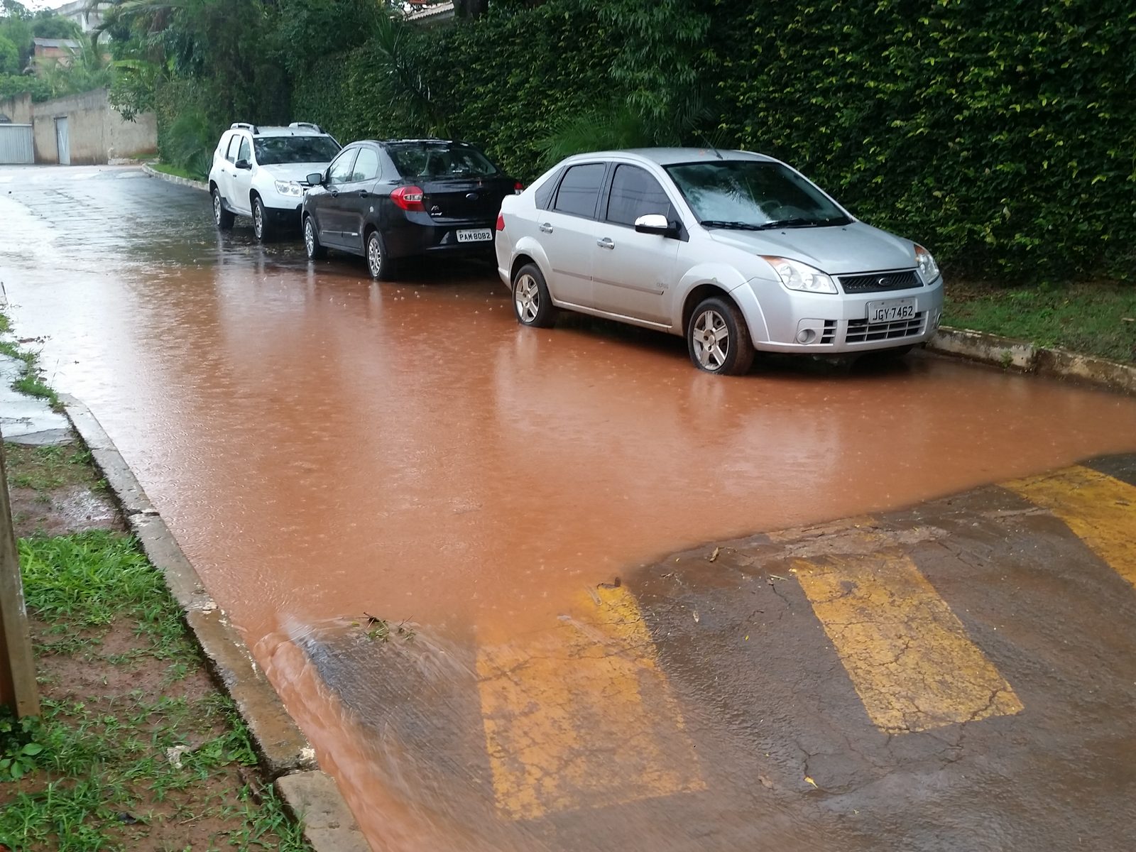 Rua alagada por enxurrada com sedimento